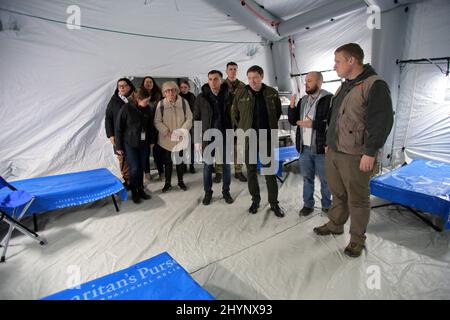 Elliott Tenpenny (R), Direktor der Internationalen Gesundheitseinheit Samaritans Purse und Leiter der regionalen Militärverwaltung von Lemberg, Maksym Kozytskyi (3. R) Nehmen Sie an der Eröffnung des Samaritans Purse Emergency Field Hospital Teil, das für die kostenlose medizinische Versorgung von Binnenvertriebenen und Patienten eingerichtet wurde, die aufgrund des wütenden Konflikts in der Region Lviv, Westukraine, behandelt werden müssen, am 14. März 2022. Foto von Alona Nikolaievych/Ukrinform/ABACAPRESS.COM Stockfoto