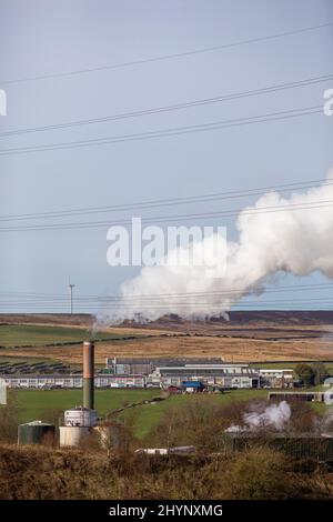 Dampfpumpen aus dem Kamin der Robinson- und Mitchells-Fabrik in der Nähe von Thornton, Bradford, England, West Yorkshire, Großbritannien. Dampf ist Wasser in der Gasphase. Dies kann durch Verdunstung oder durch Sieden auftreten, bei dem Wärme aufgebracht wird, bis das Wasser die Enthalpie der Verdampfung erreicht. Gesättigter oder überhitzter Dampf ist unsichtbar; „Team“ bezieht sich jedoch häufig auf nassen Dampf, den sichtbaren Nebel oder Aerosol von Wassertropfen, die sich aus der Kondenierung von Wasserdampf bilden. Kredit: Windmill Images/Alamy Live Nachrichten Stockfoto