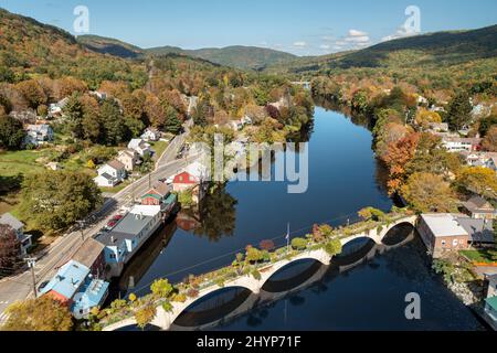 Die Bridge of Flowers überspannt den Deerfield River mit den sanften Hügeln des westlichen Massachusetts als Kulisse in Shelburne, MA im Herbst. Stockfoto