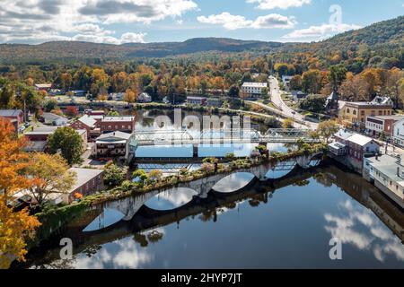 Die Bridge of Flowers überspannt den Deerfield River mit den sanften Hügeln des westlichen Massachusetts als Kulisse in Shelburne, MA im Herbst. Stockfoto