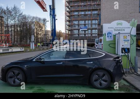 Friborg in Brisgovia, Deutschland - 19. Februar 2022: Eine statische Aufnahme eines soliden schwarzen Tesla Model 3 Dual-Motors, der am Lidl Supermarkt DC Chargi geladen wurde Stockfoto