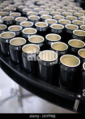 Vertikales Foto eines Rohes aus Bierdosen auf einer Plattform einer Brauerei-Verpackungsanlage Stockfoto