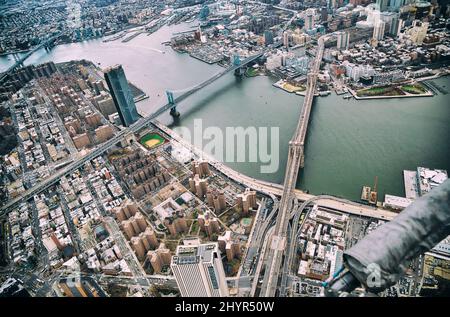 New York City von Hubschrauber. Brooklyn, Manhattan und Williamsburg Brücken mit Manhattan Wolkenkratzer an einem bewölkten Tag. Stockfoto