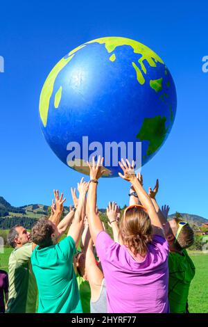 Tragen wir die Welt auf unseren Händen Stockfoto