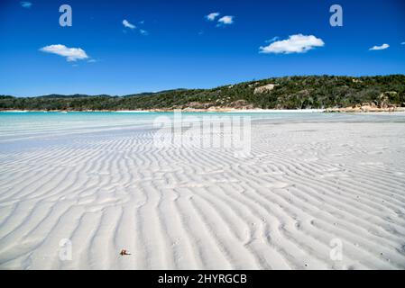 Kristallklares Wasser an einem wunderschönen Strand. Flaches Meerwasser mit Blick auf die Insel. Stockfoto