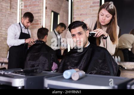 Friseur dabei Styling von Kerl mit elektrischen Haarschneider Stockfoto