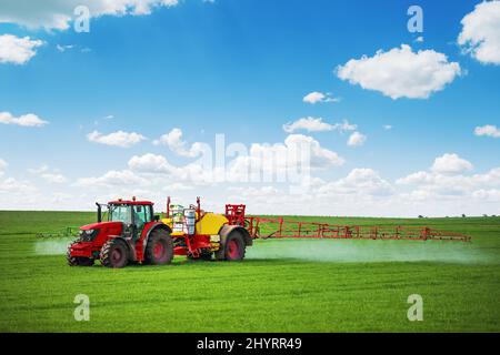 Traktor Spray Dünger Sprühen Pestizide auf grünes Feld, Landwirtschaft Hintergrund Konzept. Stockfoto