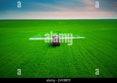 Luftaufnahme von landwirtschaftlichen Traktor Pflügen und Spritzen auf dem Feld. Stockfoto