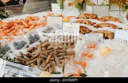 Fischstand auf der Straße, Lachs, Garnelen und weißer Fisch, eine große Auswahl an gesunden Lebensmitteln auf dem Markt Stockfoto