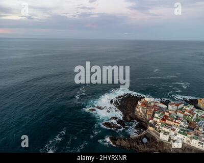 Luftaufnahme auf bunte Häuser und schwarze Lavasteine im kleinen Fischerdorf Punta Brava in der Nähe von Puerto de la Cruz, Teneriffa, Kanarische Inseln bei Sonnenaufgang Stockfoto
