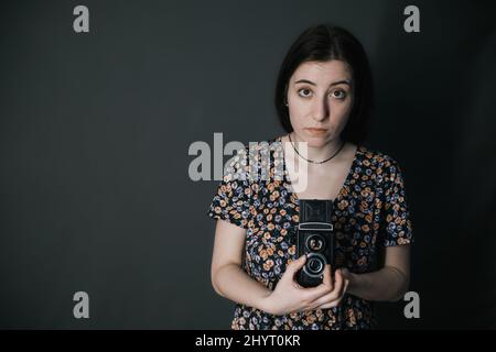 Junge armenische ukrainische Frau macht Fotos mit Vintage-Kamera alte Schule Stockfoto