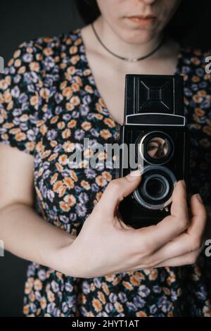 Junge armenische ukrainische Frau macht Fotos mit Vintage-Kamera alte Schule Stockfoto