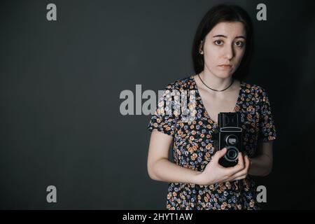 Junge armenische ukrainische Frau macht Fotos mit Vintage-Kamera alte Schule Stockfoto