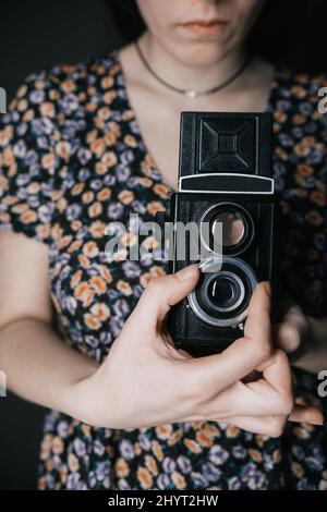 Junge armenische ukrainische Frau macht Fotos mit Vintage-Kamera alte Schule Stockfoto