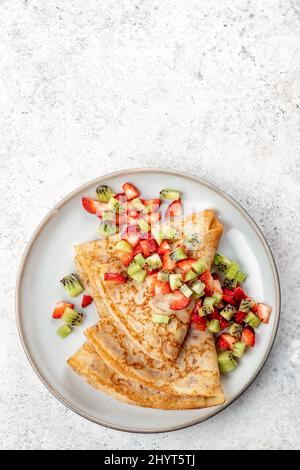 Gesunde Crepes mit Früchten Kiwi und Erdbeere. Gesundes französisches Frühstück Stockfoto