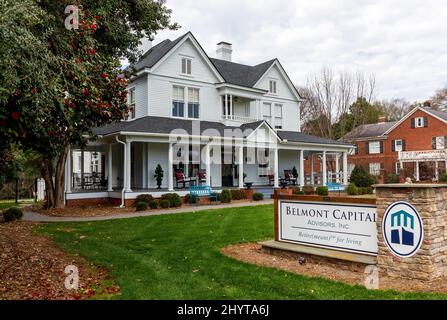 BELMONT, NC, USA-8 MARCH 2022: Elegantes, weißes Klappbretthaus mit umhüllter Veranda, jetzt Büros von Belmont Capital Advisors, Inc Stockfoto