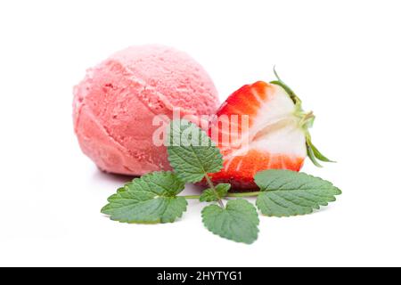 Eine Kugel Stawberry-Eis, verziert mit Minzblättern und Erdbeeren Stockfoto
