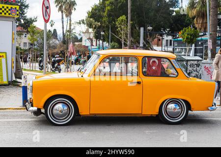 Antalya, Türkei – Februar 20 2022: Gelber Oldtimer Trabant 601s auf dem Hintergrund einer Stadtstraße, Vorderansicht. Stockfoto
