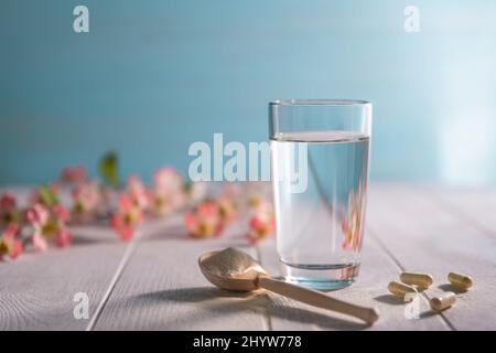 matcha Collagen Pulver in Löffel und Glas Wasser Stockfoto