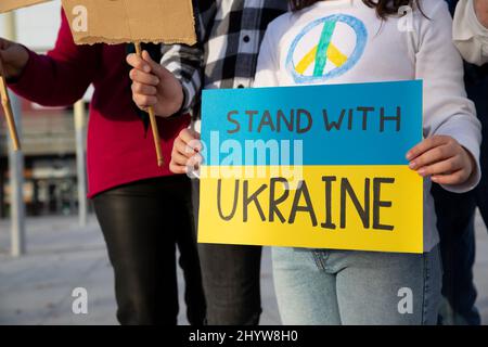 Anti-Kriegs-Demonstranten protestieren auf der Straße gegen die Invasion russischer Truppen in der Ukraine. Eine Gruppe von Personen, die nicht erkennbar sind. Stockfoto