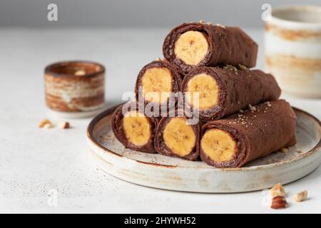 Banana gefüllte Schokolade Crepes auf grauem Hintergrund Stockfoto