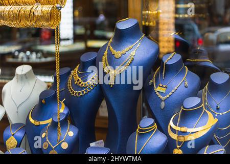 Schaufenster eines Juwelierladens mit einer riesigen Auswahl an goldenen Schmuckarmbändern, Ketten, Ringen und Ohrringen auf einem weiblichen Relief Stockfoto