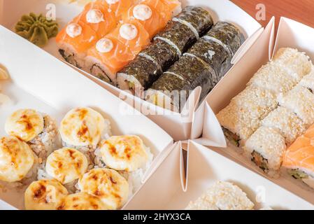 Lieferung von Lebensmitteln. Japanische Brötchen in Papierkartons. Stockfoto