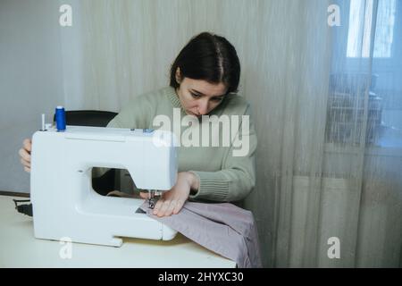 Frau näht zu Hause an einer Schreibmaschine Stockfoto