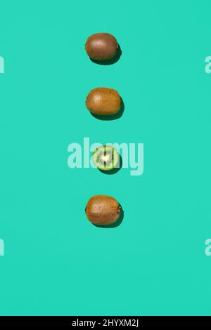 Minimale Zusammensetzung aus frischen grünen Kiwi-Früchten in Linie auf hellblauem Hintergrund, gesunde Ernährung und veganes Konzept, Kopierraum Stockfoto
