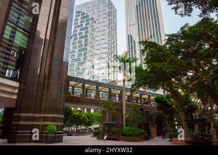 Überdachter Gang. Hong Kong Island, China. Wunderschöne Aufnahme einer Fußgängerbrücke mit Wolkenkratzern im Hintergrund. Geschäftsviertel Stockfoto
