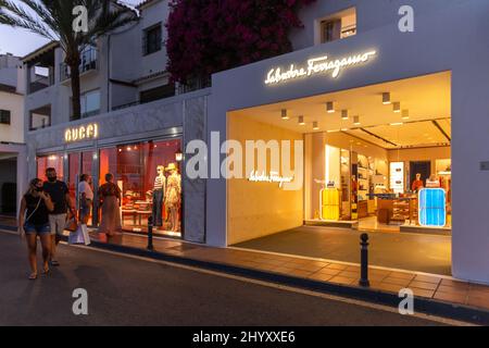 Nachtaufnahmen in luxuriöser und berühmter Lage von Marbella -Puerto BANUS Bay. Blick auf den Salvatore Ferragamo Store, im Einkaufsviertel des Hafens Stockfoto