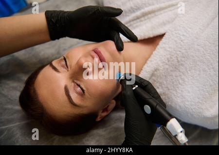 Gesichtshautpflege. Nahaufnahme einer Frau, die eine Behandlung mit Hydro-Mikrodermabrasion-Peeling im kosmetischen Beauty-Spa erhält. Hydra-Staubsauger. Exfoli Stockfoto