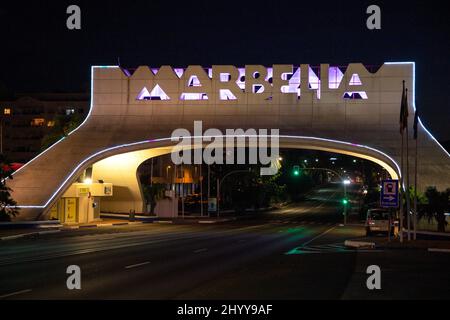 Eingang in Marbella, berühmtes und emblematisches Zeichen, Bogen, Nachtsicht - in verschiedenen Farben beleuchtet. Nachtaufnahmen Stockfoto