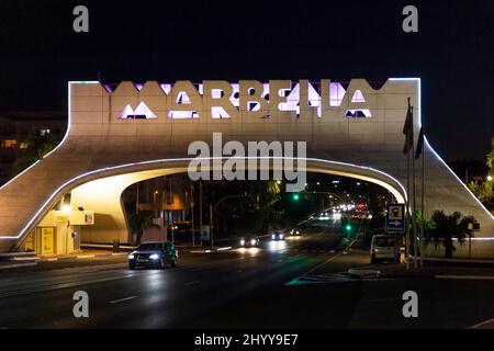 Eingang in Marbella, berühmtes und emblematisches Zeichen, Bogen, Nachtsicht - in verschiedenen Farben beleuchtet. Nachtaufnahmen Stockfoto