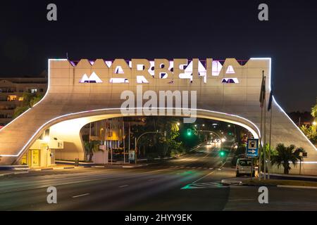 Eingang in Marbella, berühmtes und emblematisches Zeichen, Bogen, Nachtsicht - in verschiedenen Farben beleuchtet. Nachtaufnahmen Stockfoto