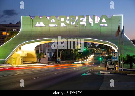 Eingang in Marbella, berühmtes und emblematisches Zeichen, Bogen, Nachtsicht - in verschiedenen Farben beleuchtet. Nachtaufnahmen Stockfoto