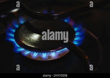 Ein blaues Gasflammenkochfeld leuchtet auf einem heimischen Küchenherd Stockfoto