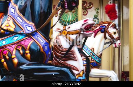 Nahaufnahme von farbenfrohen Pferden bei einem traditionellen traditionellen traditionellen Karussell-Ritt auf einem Jahrmarkt Stockfoto