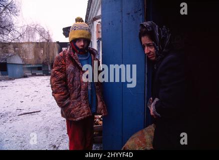 Erster tschetschenischer Unabhängigkeitskrieg von Russland (1994-1995). Tschetschenische Mutter und achtjährige Tochter an der Tür zum Keller einer bombardierten Schule südlich von Grosny, der Hauptstadt der tschetschenischen Republik. 28 Dezember 1994. Stockfoto