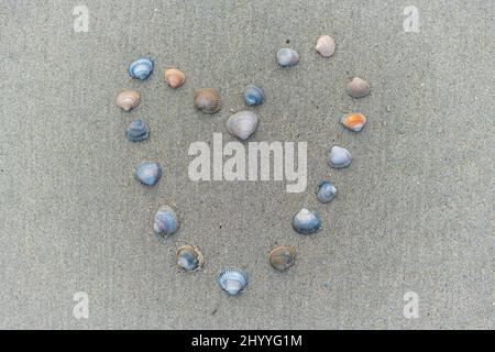 In der Mitte des Sandes wird von Juist ein Herz gezeichnet und mit Muscheln dargestellt Stockfoto