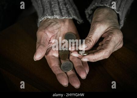 Nahaufnahme der Hände älterer Frauen mit Euromünzen. Rentnerin zählt Geld in ihre Hände Stockfoto