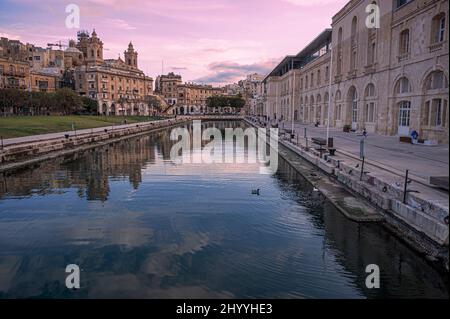 Sonnenuntergang über einem kleinen Kanal in Cospicua, Malta Stockfoto