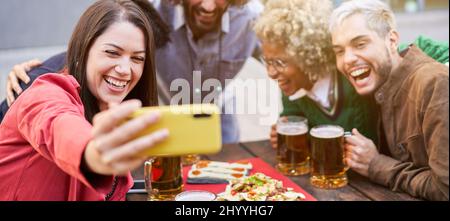 Panoramafoto einer vielfältigen Gruppe von Freunden, die ein Selfie auf einer Party im Freien machen Stockfoto