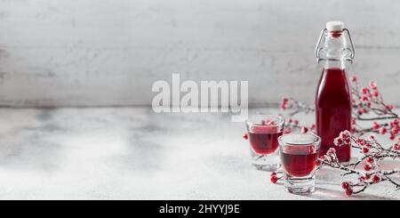 Zwei Gläser roten Cocktail, Wodka oder Likör auf hellem Hintergrund. Alkohol Shot Drink Konzept Stockfoto