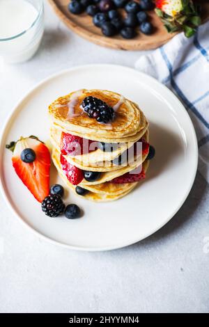 Vanillepfannkuchen mit Früchten und Beeren. Ansicht von oben. Stockfoto