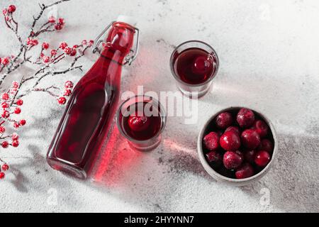 Hausgemachter infundierten Wodka, Tinktur oder Likör aus roter Kirsche auf weißem Hintergrund. Berry alkoholische Getränke Konzept. Stockfoto