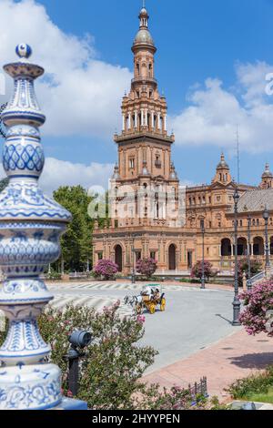 Schöner Platz Espana, im Zentrum von Sevilla. Pandemiezeit, mit sehr wenigen Touristen. Pferdekutsche vorbei. Blues Himmel wenige Wolken. Stockfoto