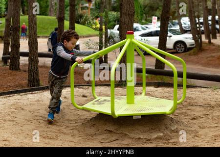 Foto eines Kindes, das Spaß am Spinning-Spiel im Park hat Stockfoto