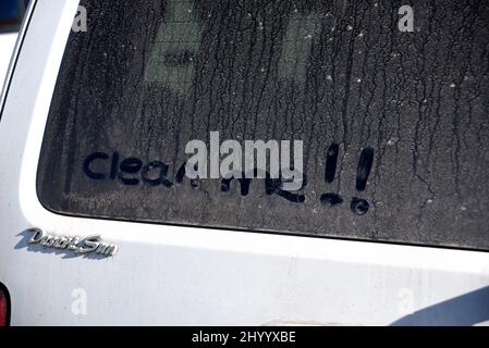 „Clean Me“ steht auf dem schmutzigen Fenster eines Autos, das in Santa Fe, New Mexico, geparkt wurde. Stockfoto