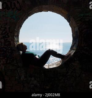 Menschen in einer kreisförmigen Steinmulde vor der Stadt Calpe Stockfoto